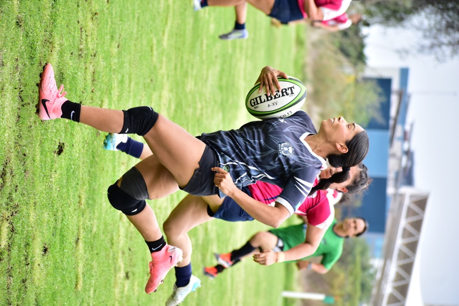 Jugadora avanza con el balón durante una jugada de rugby