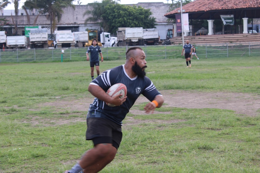Integrante del equipo corre con el balón durante una jugada